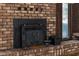 Close-up of the living room fireplace featuring a black insert and brick surround at 219 Caropine Dr., Surfside Beach, SC 29575