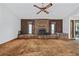 Open living room featuring a brick fireplace, wood paneling, and a ceiling fan at 219 Caropine Dr., Surfside Beach, SC 29575