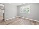 Cozy bedroom with hardwood floors, natural light from the bright window, and neutral paint at 2415 Magnolia Lane, Little River, SC 29566