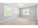 Bright bedroom with neutral carpet and walls, large windows and ceiling fan at 2415 Magnolia Lane, Little River, SC 29566