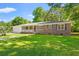 Charming brick home featuring a well-manicured lawn and a quaint front porch with a lovely sunburst design at 2415 Magnolia Lane, Little River, SC 29566