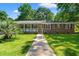 Inviting brick home with a sunny front yard and a welcoming walkway leading to the entrance at 2415 Magnolia Lane, Little River, SC 29566