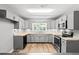 Modern kitchen with shaker cabinets, stone countertops, stainless steel appliances, and durable flooring at 2415 Magnolia Lane, Little River, SC 29566