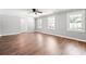Spacious living room with hardwood floors, neutral walls, ceiling fan, and an open doorway to another room at 2415 Magnolia Lane, Little River, SC 29566