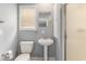 Well-lit bathroom featuring a pedestal sink, toilet, and a glass-enclosed shower stall at 2479 Glen Dr., Little River, SC 29566