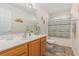 Bathroom with wooden cabinets, large mirror, and combination shower/tub at 2479 Glen Dr., Little River, SC 29566