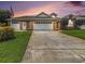 Lovely brick home featuring a three-car garage, manicured lawn, and American flag at 2479 Glen Dr., Little River, SC 29566