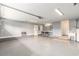 Clean garage featuring epoxy floor, lighting, wall heater, and storage shelves with utility sink at 2479 Glen Dr., Little River, SC 29566