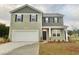 Two-story home with green siding, black shutters, white garage door, and manicured lawn at 292 Clear Lake Dr., Conway, SC 29526
