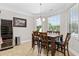 Dining area features a dark wood table, wine fridge and large windows overlooking the lush landscaping and pool at 310 Babylon Pine Dr., Myrtle Beach, SC 29579