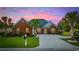 Charming brick home with manicured lawn, mature palm trees, and a spacious driveway under a beautiful pink and purple sky at 310 Babylon Pine Dr., Myrtle Beach, SC 29579