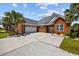 Attractive brick home with a wide driveway leading to an attached two-car garage and tropical landscaping at 310 Babylon Pine Dr., Myrtle Beach, SC 29579