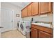 Functional laundry room features ample cabinet storage, modern washer and dryer, and granite countertop at 310 Babylon Pine Dr., Myrtle Beach, SC 29579
