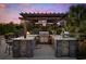 Outdoor kitchen with a built-in grill, stone countertops, and a wooden pergola at 310 Babylon Pine Dr., Myrtle Beach, SC 29579
