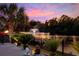 Scenic water view with a fountain, framed by lush greenery and palm trees, reflecting the colorful sunset at 310 Babylon Pine Dr., Myrtle Beach, SC 29579