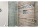 Custom shower with decorative tile inlays, grab bar, and glass door at 3211 S Ocean Blvd. # 204, Myrtle Beach, SC 29577