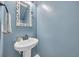 Clean bathroom with a pedestal sink, decorative mirror, and fresh blue paint at 338 St. Julian Ln., Myrtle Beach, SC 29579