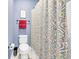 Cozy bathroom displaying a patterned shower curtain, a toilet with a red towel, and elegant blue walls at 338 St. Julian Ln., Myrtle Beach, SC 29579