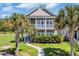 Charming two-story home with double porches and lush landscaping featuring mature palm trees at 338 St. Julian Ln., Myrtle Beach, SC 29579