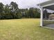 Expansive backyard with lush grass, trees, and a screened porch at 3391 Moss Bridge Ln., Myrtle Beach, SC 29579