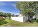 White fenced backyard featuring a large tree and bright green grass and partial view of the home at 3910 Stillwood Dr., Myrtle Beach, SC 29588