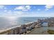 Breathtaking aerial view of the oceanfront community with a long fishing pier on a sunny day with partial clouds at 4000 North Ocean Blvd. # 1002, North Myrtle Beach, SC 29582
