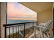 Relaxing balcony featuring two chairs with a view of the beach, ocean, and sunset sky at 4000 North Ocean Blvd. # 1002, North Myrtle Beach, SC 29582