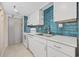 Galley kitchen featuring modern appliances and stylish blue backsplash at 4000 North Ocean Blvd. # 1002, North Myrtle Beach, SC 29582