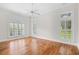 Sunlit bedroom featuring hardwood floors, a ceiling fan, and a large window with shutters at 423 Chapman Loop, Pawleys Island, SC 29585