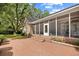 Brick home with a screened-in porch and landscaped yard, surrounded by mature trees at 423 Chapman Loop, Pawleys Island, SC 29585