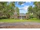 Charming brick home with a screened-in porch, surrounded by lush trees and well-kept lawn at 423 Chapman Loop, Pawleys Island, SC 29585