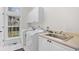 A clean laundry room with white cabinets, sink, and a large window at 423 Chapman Loop, Pawleys Island, SC 29585