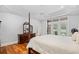 Bright main bedroom featuring a four-poster bed, tray ceiling, and hardwood floors at 423 Chapman Loop, Pawleys Island, SC 29585