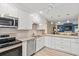 A modern kitchen with white cabinets and stainless appliances seamlessly connects to a spacious living area at 430 Ocean Creek Dr. # 2534, Myrtle Beach, SC 29572