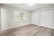 Bedroom with two closets, neutral walls, modern light-colored wood-look flooring and a window with blinds at 4300 Crows Nest Ct., Myrtle Beach, SC 29579