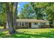 The charming exterior features a brick and white facade with blue shutters complemented by a lush, green lawn at 4300 Crows Nest Ct., Myrtle Beach, SC 29579