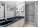 Bathroom featuring a double sink vanity with black countertop and a large mirror at 4406 Barcelona Ln., Little River, SC 29566