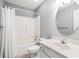 This bathroom features neutral walls, white vanity, shower with curtain, and an oval mirror at 4406 Barcelona Ln., Little River, SC 29566