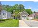 Beautiful home with green front yard and trees providing shade, attached garage, and a welcoming porch at 4406 Barcelona Ln., Little River, SC 29566