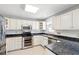 Well-lit kitchen featuring white cabinets, stainless steel appliances, and a black countertop at 4406 Barcelona Ln., Little River, SC 29566