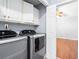 Laundry room featuring modern washer and dryer, ample cabinet space, and laminate flooring at 4406 Barcelona Ln., Little River, SC 29566
