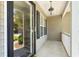 Inviting porch with elegant lighting, classic columns, and a glimpse of the landscaped yard at 4406 Barcelona Ln., Little River, SC 29566