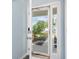 View through open front door, showcasing a modern digital lock, elegant sidelights, and a glimpse of the landscaped yard at 4603 East Walkerton Rd., Myrtle Beach, SC 29579