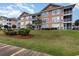 Well-manicured condo with a beautiful lawn, landscaping, and exterior balconies to enjoy the outdoors at 4633 Lightkeepers Way # 5-F, Little River, SC 29566
