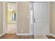 Inviting entryway showcasing wood floors, a white front door, and a glimpse into a bright, open living space at 4633 Lightkeepers Way # 5-F, Little River, SC 29566