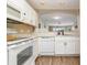 Kitchen featuring white cabinets, modern appliances, wood-look floors, and a view to the living area at 4633 Lightkeepers Way # 5-F, Little River, SC 29566