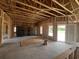 Unfinished room features open floorplan, wooden framing, and rear glass door leading to the outdoors at 475 Highway 348, Loris, SC 29569