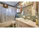 Vintage bathroom with blue tiling, a white sink vanity, and a patterned shower curtain at 4810 Circle Dr., Loris, SC 29569