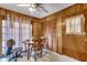 Cozy dining area featuring wood paneling, a ceiling fan, and a round table near natural light from a window at 4810 Circle Dr., Loris, SC 29569