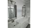 Bathroom with double vanities, framed mirrors, and a luxurious tiled walk-in shower at 4823 Riverside Dr., North Myrtle Beach, SC 29582